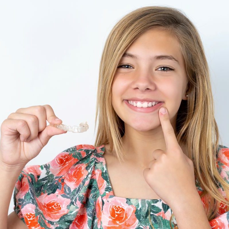 Teen girl smiling with her Invisalign aligners