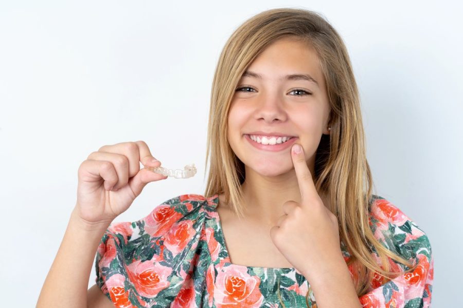 Teen girl smiling with her Invisalign aligners